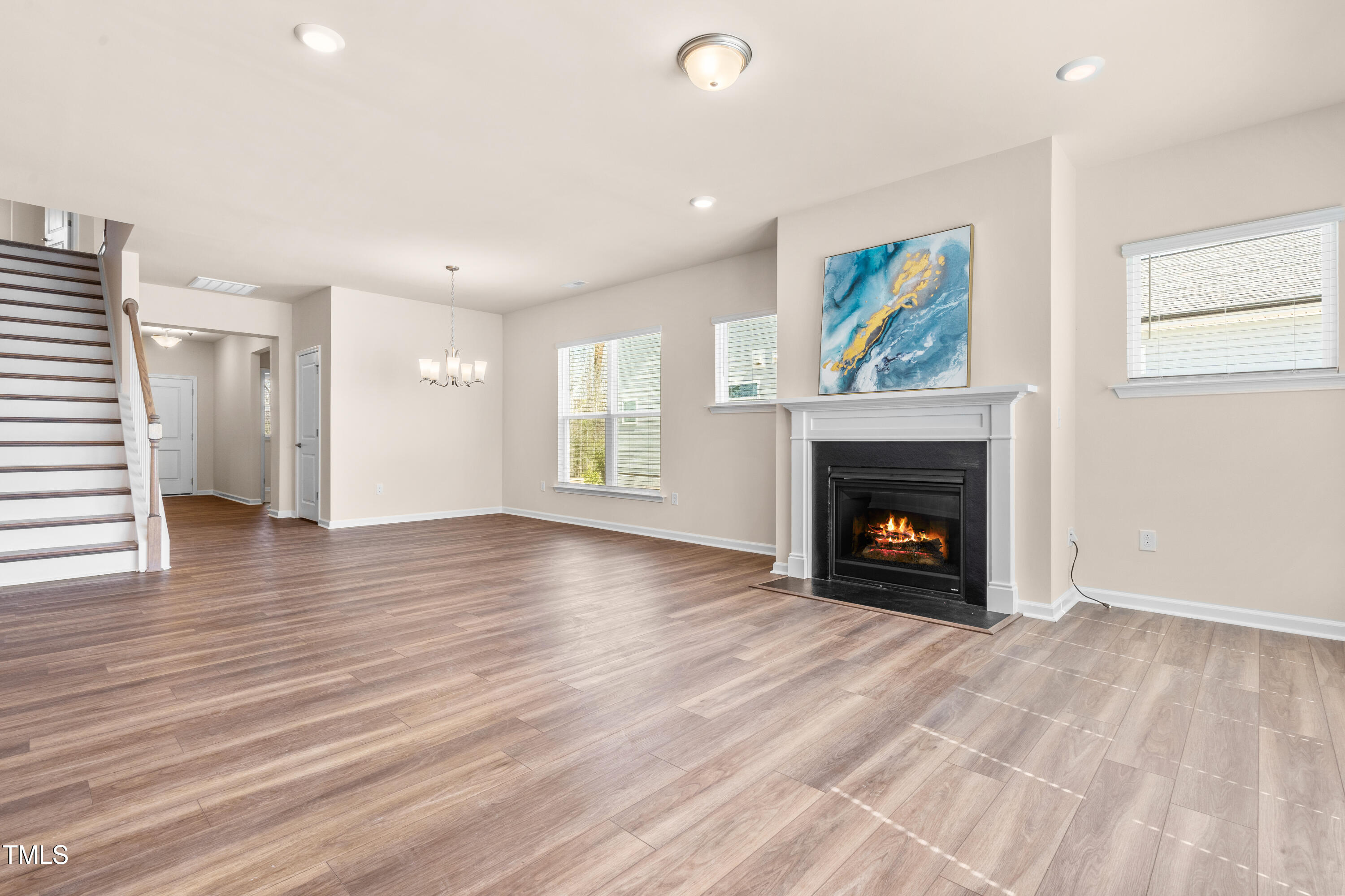 5800 Agrinio Way Raleigh, NC 27603 - Photo 4 of 38 an empty room with wooden floor fireplace and window