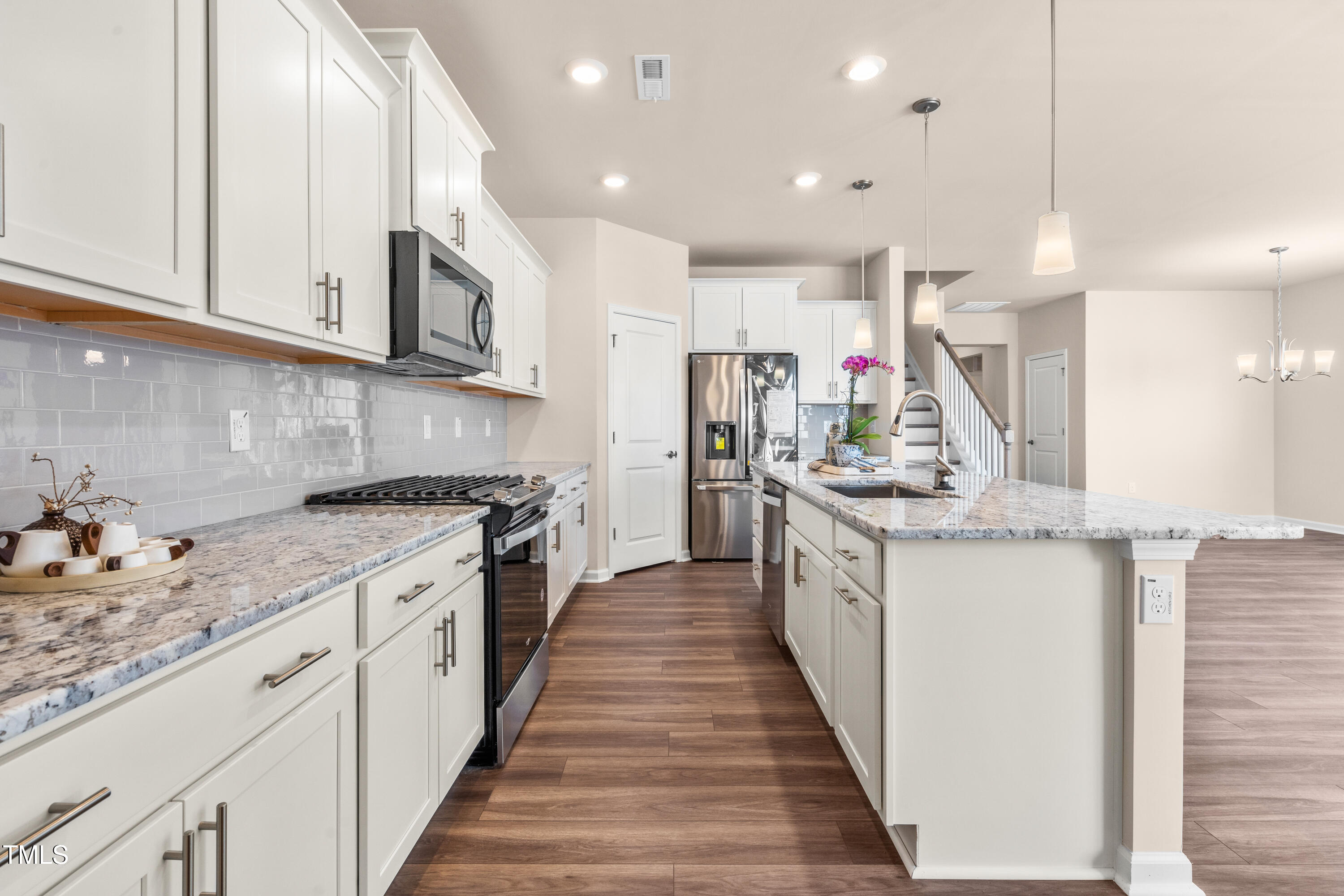 5800 Agrinio Way Raleigh, NC 27603 - Photo 7 of 38 a kitchen with kitchen island granite countertop lots of counter top space and stainless steel appliances