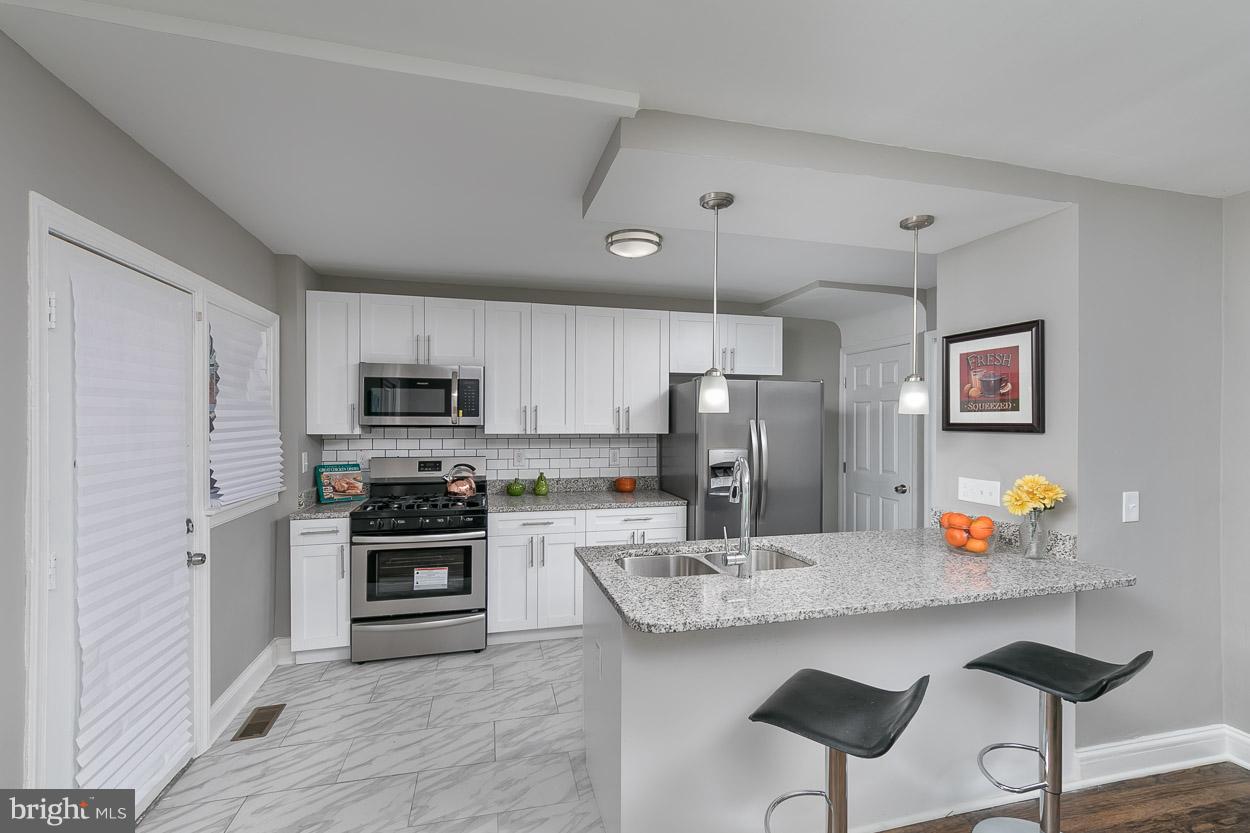 3924 Yolando Road Baltimore, MD 21218 - Photo 7 of 29 a kitchen with stainless steel appliances a sink a stove a refrigerator cabinets and dining table