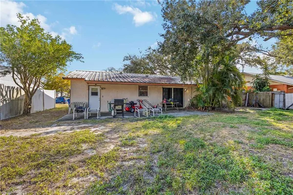a view of a house with backyard and a tree