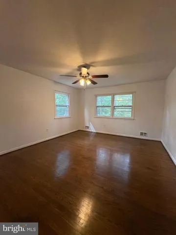 a view of a livingroom with wooden floor window and a kitchen
