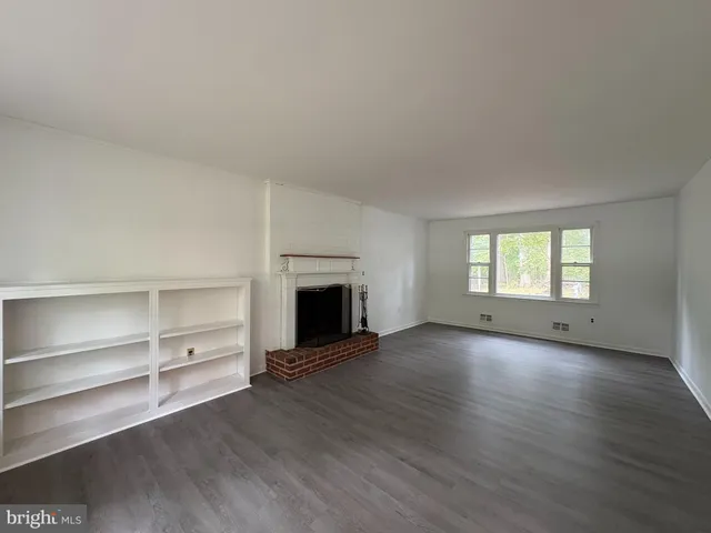 a view of an empty room with a fireplace and a window