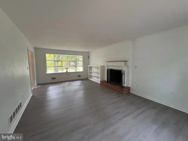 an empty room with wooden floor and a window