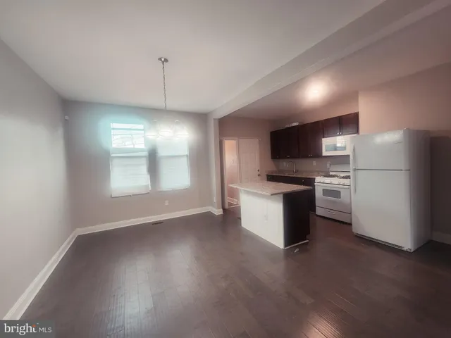 a kitchen with a refrigerator and a stove top oven