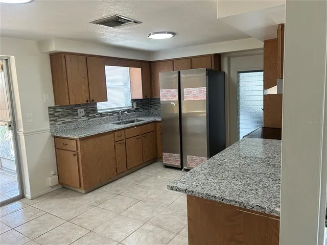 a kitchen with stainless steel appliances granite countertop a refrigerator and a sink