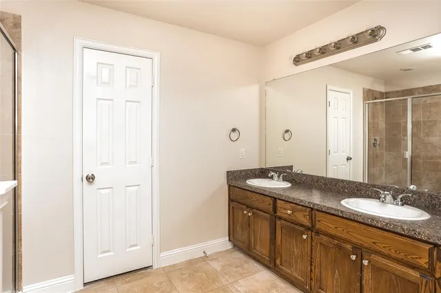 a bathroom with a granite countertop sink a mirror and a shower