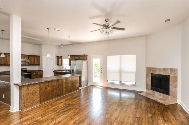 a large kitchen with stainless steel appliances granite countertop a stove top oven a sink with wooden floors and white cabinets