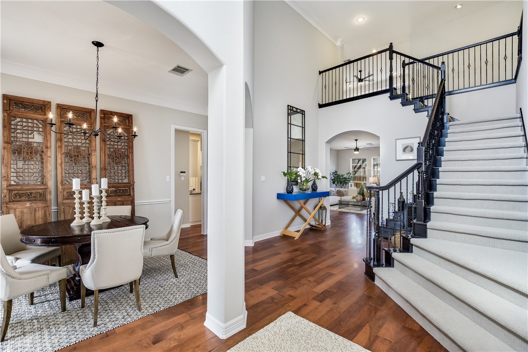 a view of a livingroom with furniture staircase wooden floor and windows