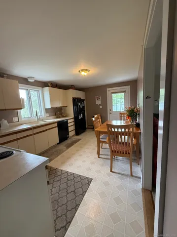 a kitchen with stainless steel appliances kitchen island granite countertop a refrigerator and cabinets