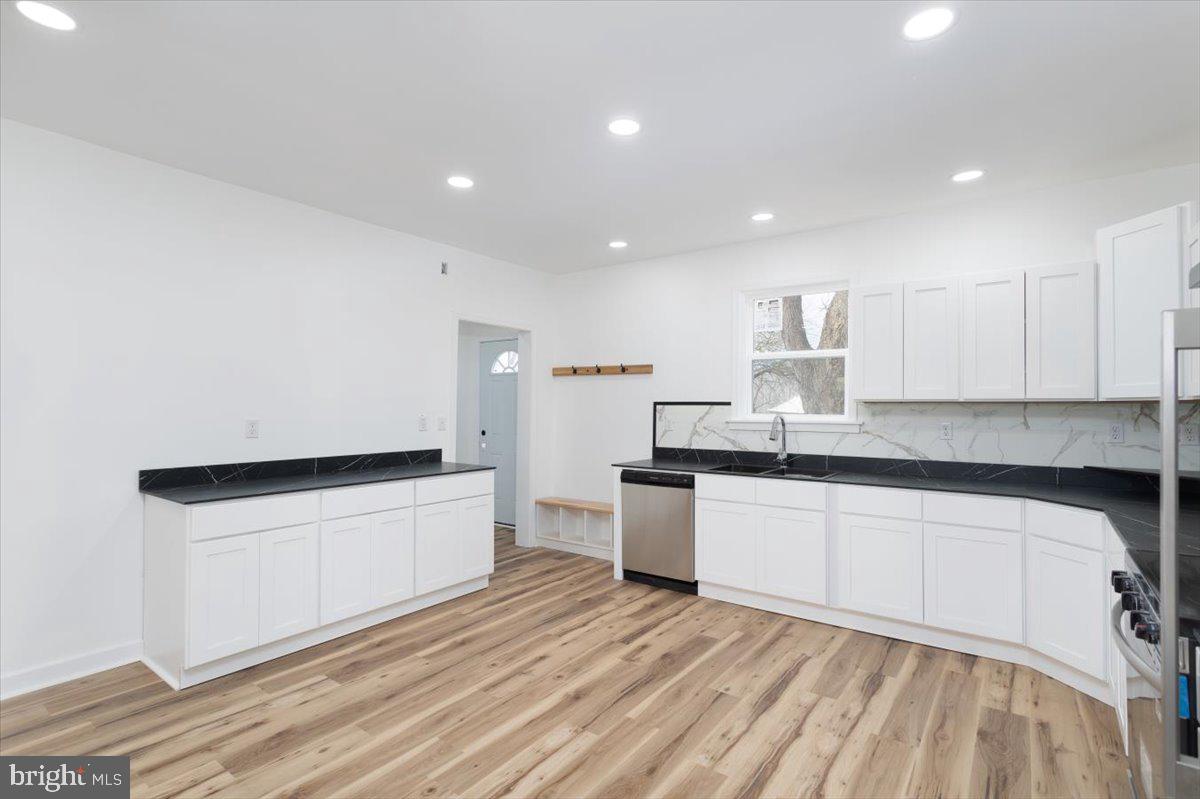 5026 Bethlehem Road Preston, MD 21655 - Photo 12 of 25 a large kitchen with granite countertop a white stove top oven and white cabinets