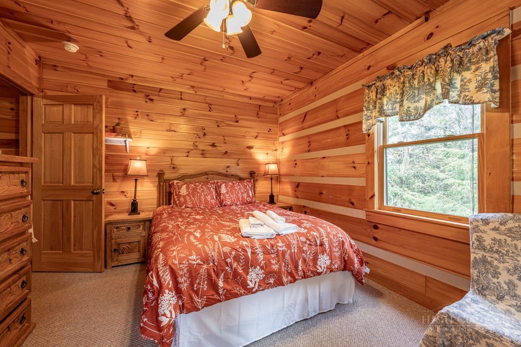 197 Woodby Ridge Road Vilas, NC 28692 - Photo 16 of 45 a bed sitting in a bedroom next to a window