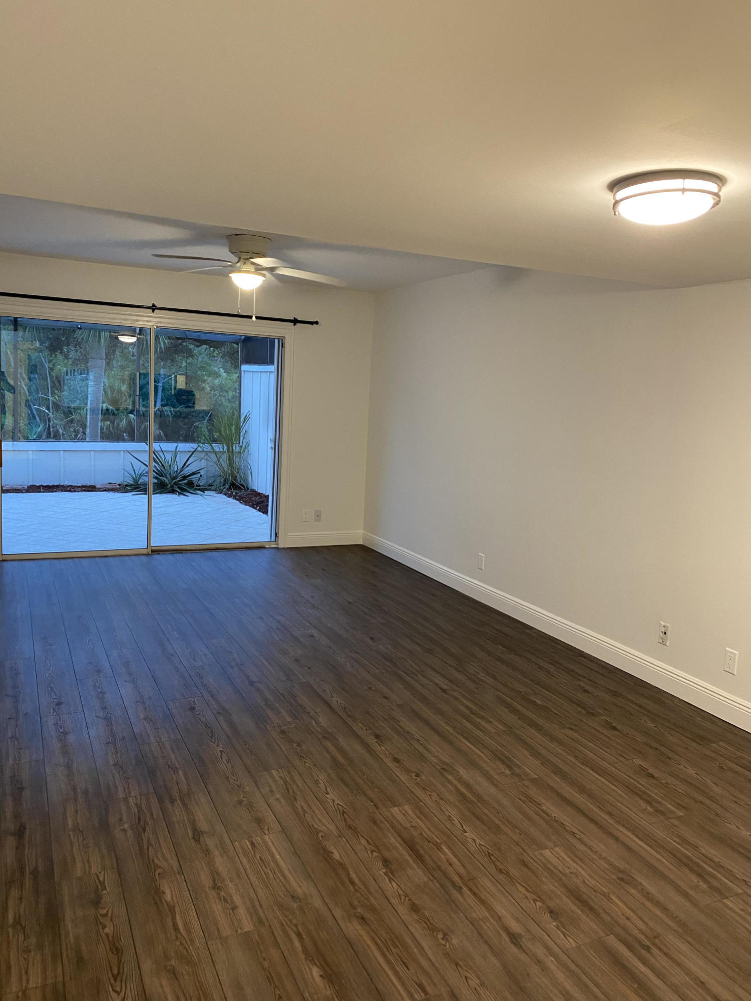 6183 Riverwalk Lane, Unit 3 Jupiter, FL 33458 - Photo 11 of 35 a view of an empty room with wooden floor and a window