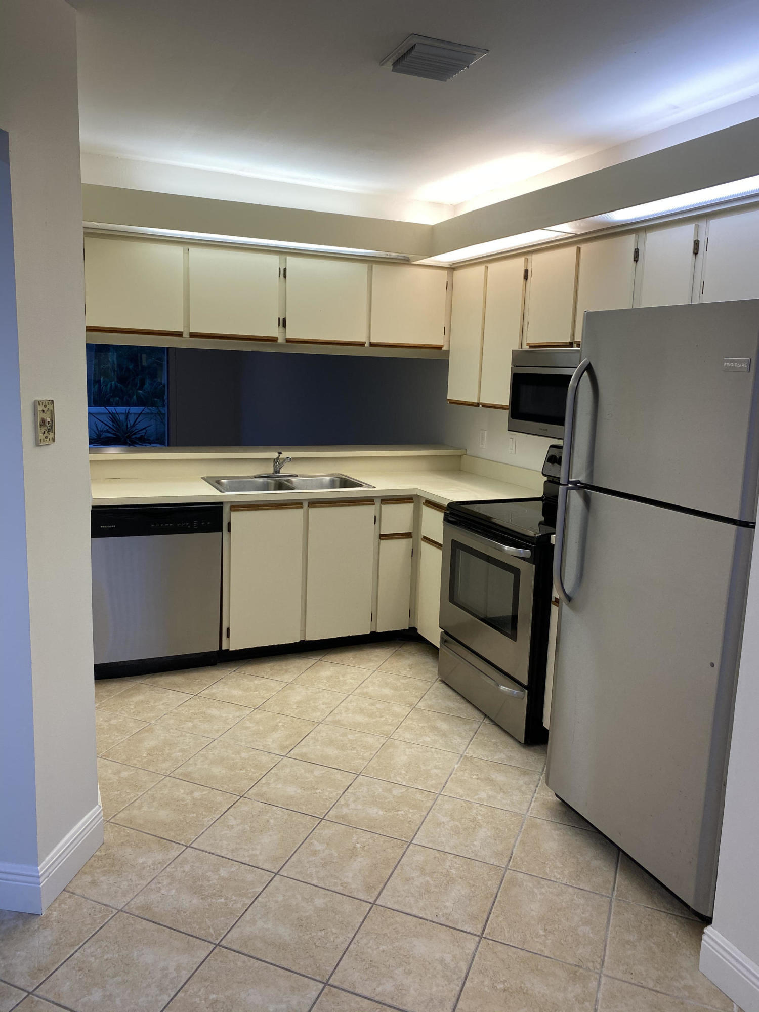 6183 Riverwalk Lane, Unit 3 Jupiter, FL 33458 - Photo 6 of 35 a kitchen with stainless steel appliances granite countertop a sink and a refrigerator