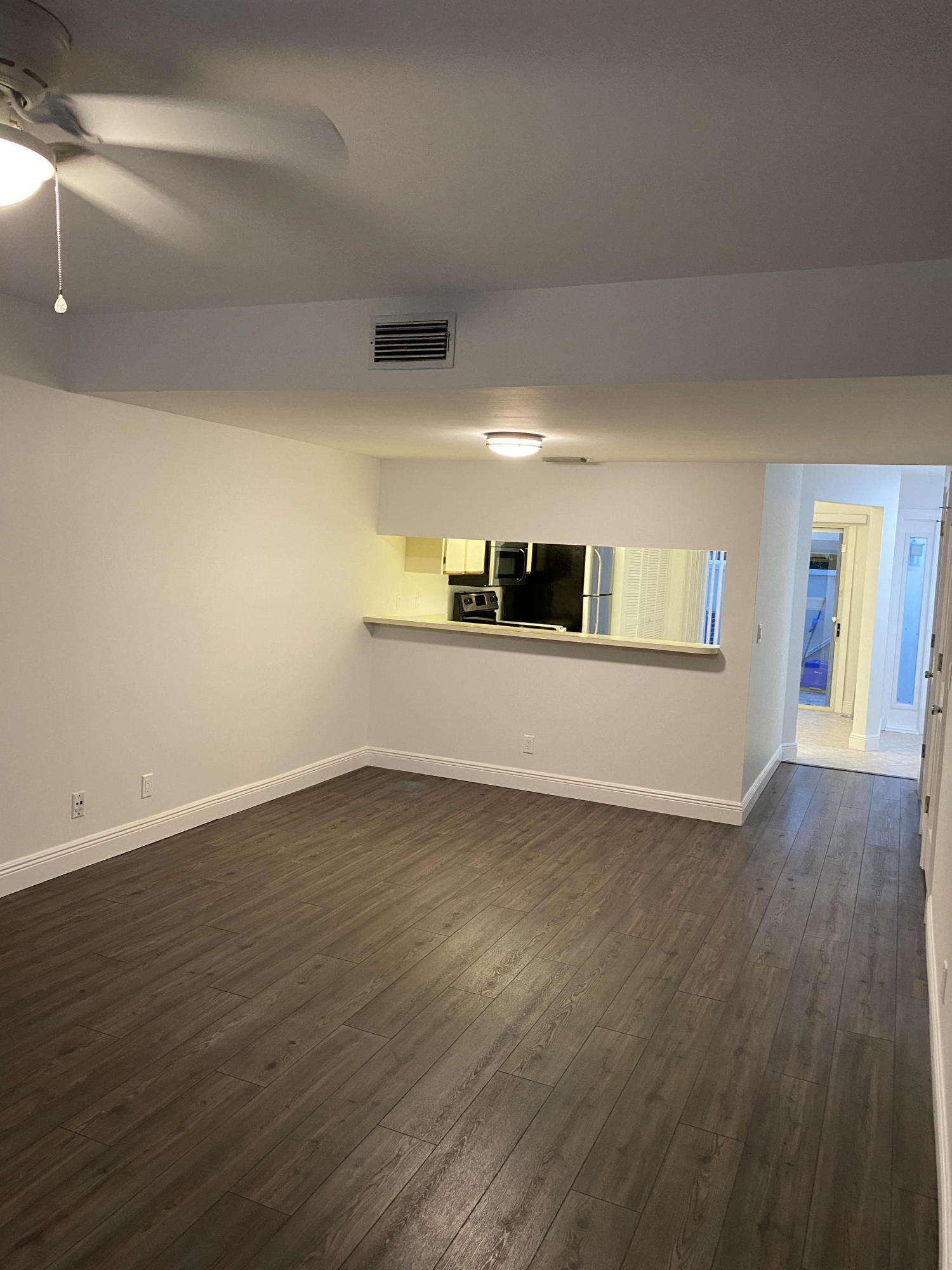 6183 Riverwalk Lane, Unit 3 Jupiter, FL 33458 - Photo 8 of 35 a view of a kitchen with wooden floor and electronic appliances