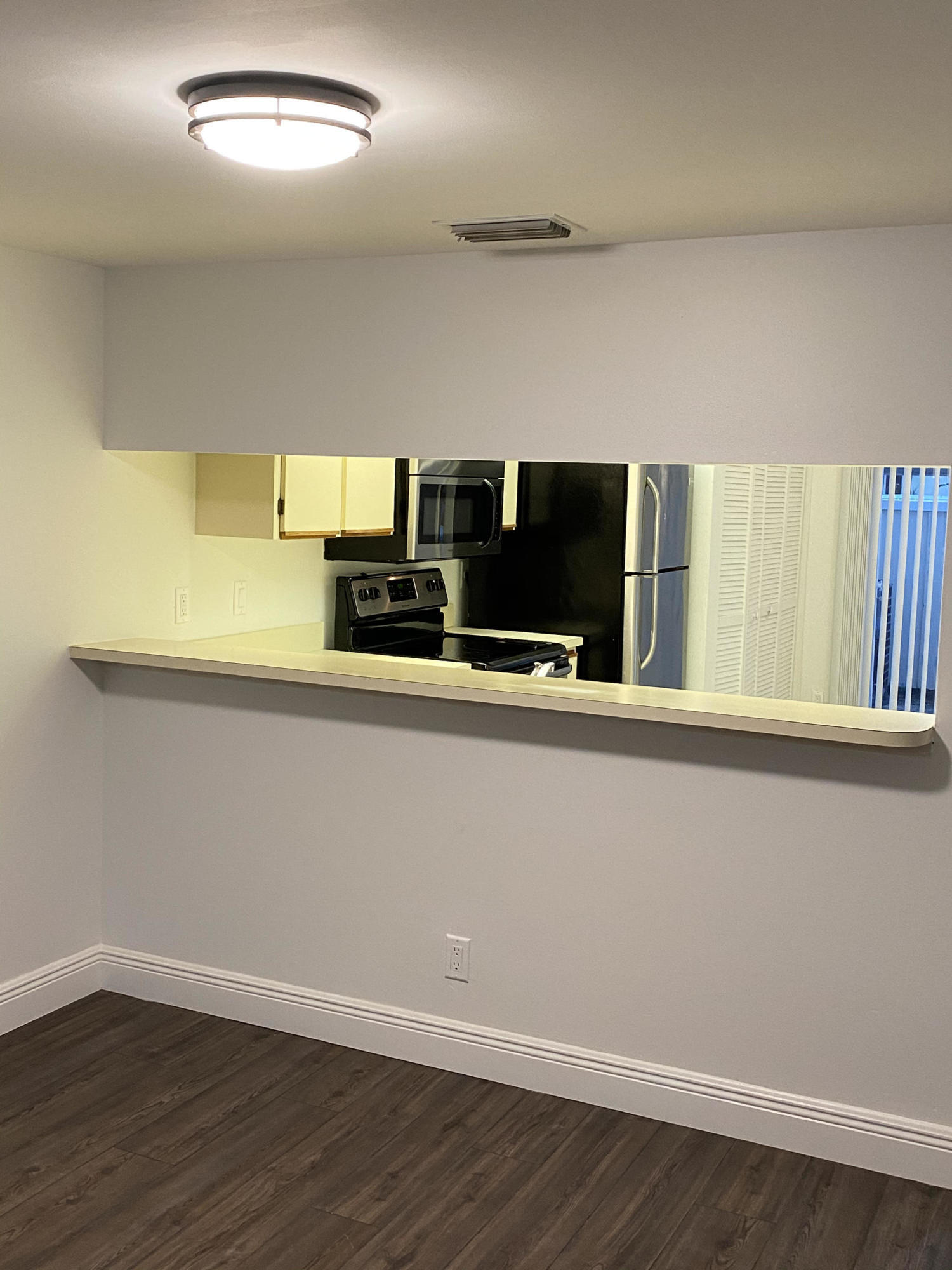 6183 Riverwalk Lane, Unit 3 Jupiter, FL 33458 - Photo 9 of 35 a room with a wooden floor and chandelier
