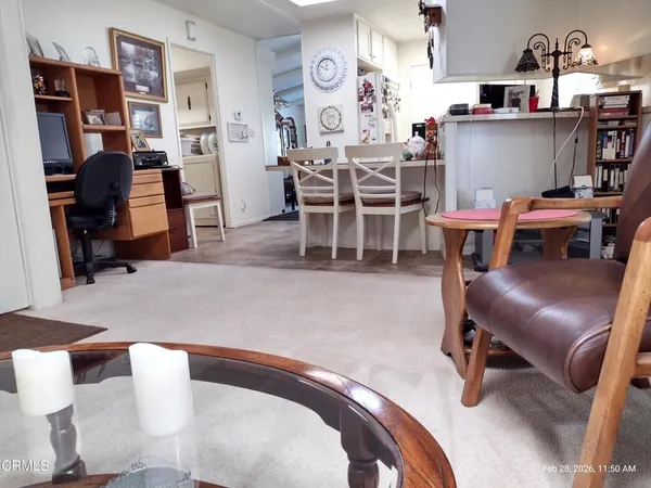 a living room with furniture and a painting on the wall