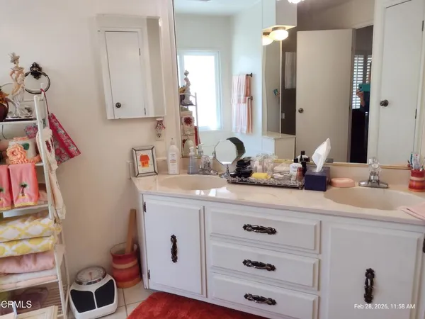 a white toilet sitting next to a bathroom sink and vanity