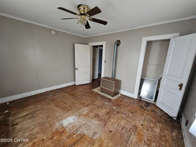 a view of empty room with wooden floor