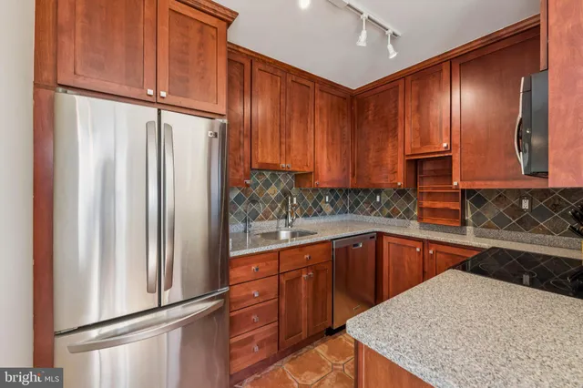 a view of a kitchen with stainless steel appliances granite countertop a refrigerator and a sink