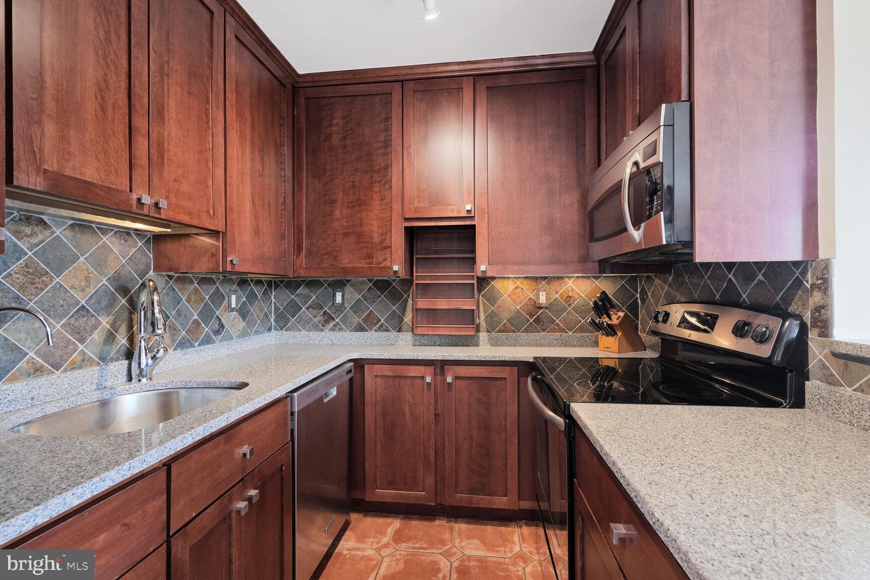 2501 Calvert Street Northwest, Unit 701 Washington, DC 20008 - Photo 12 of 29 a kitchen with stainless steel appliances granite countertop a sink stove and cabinets