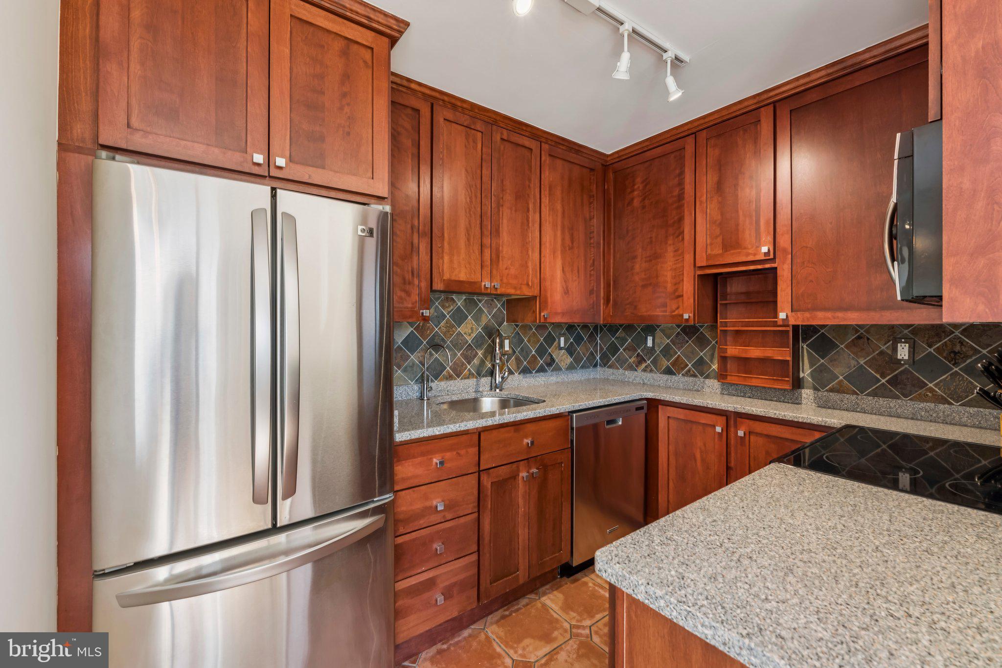2501 Calvert Street Northwest, Unit 701 Washington, DC 20008 - Photo 13 of 31 a kitchen with stainless steel appliances granite countertop a refrigerator and a sink