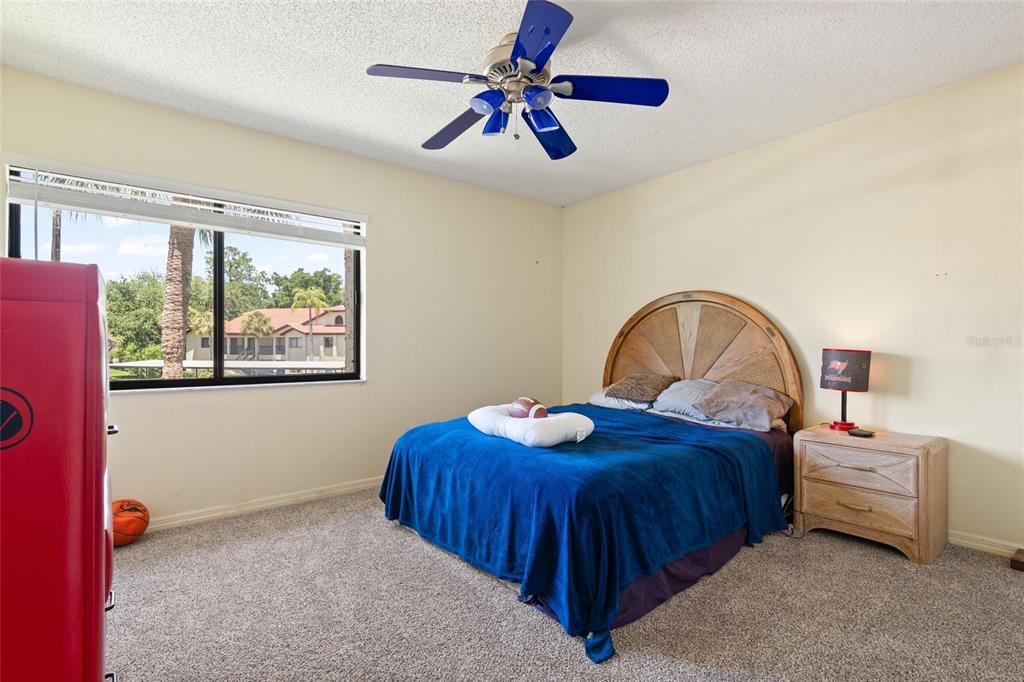 1801 East Lake Road South, Unit 4E Palm Harbor, FL 34685 - Photo 21 of 26 a bedroom with a bed and a window