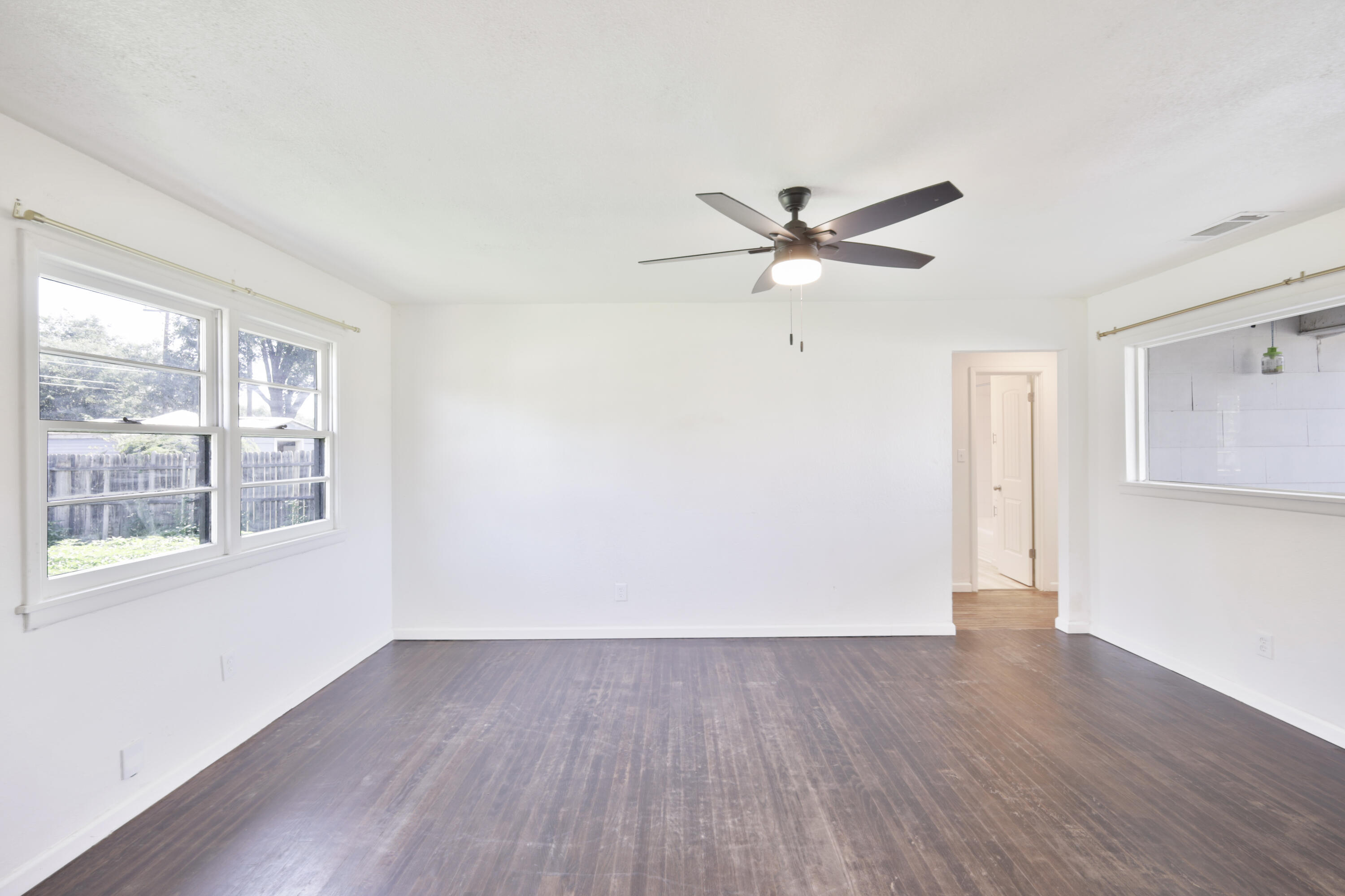 3812 31st Street Lubbock, TX 79410 - Photo 5 of 16 wooden floor in an empty room with a window