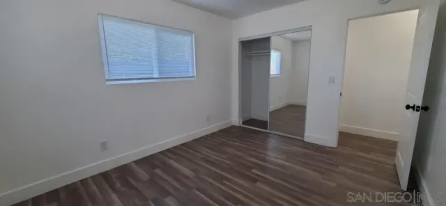 an empty room with wooden floor and closet