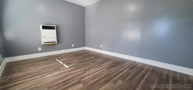a view of a room with wooden floor and white walls