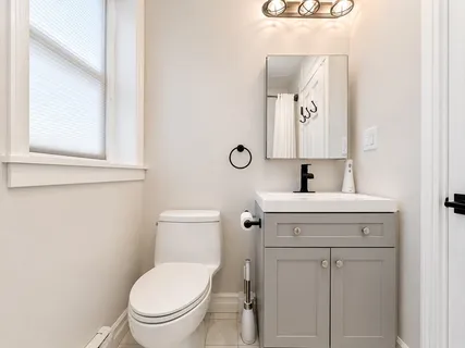 a bathroom with a toilet sink vanity and mirror