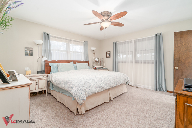21200 South River Road Frankfort, IL 60423 - Photo 14 of 51 a bedroom with a bed and a chandelier
