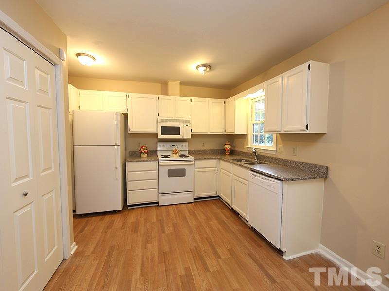 6108 New Market Way Raleigh, NC 27609 - Photo 3 of 17 a kitchen with a refrigerator a sink and dishwasher with wooden floor