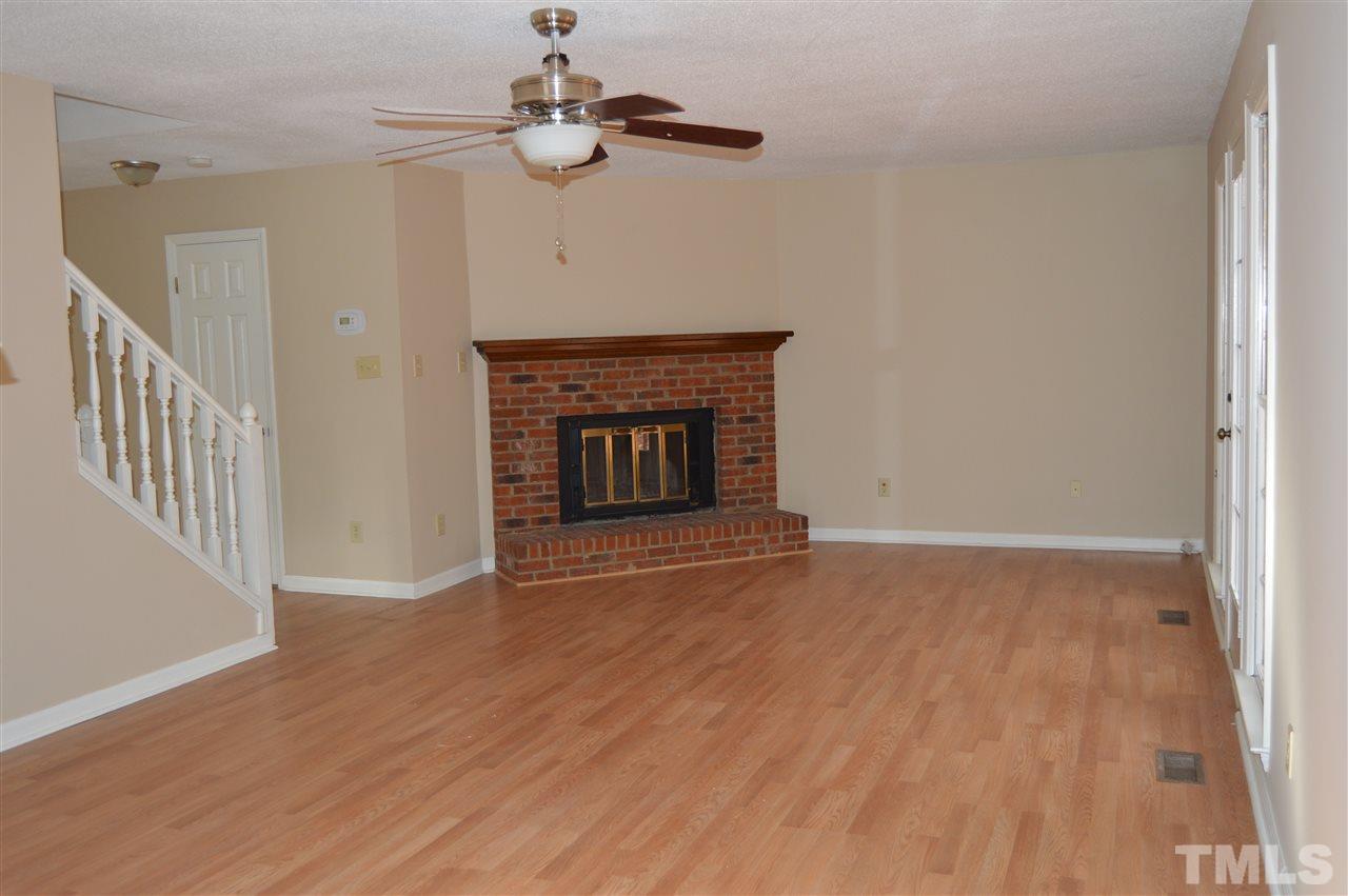 6108 New Market Way Raleigh, NC 27609 - Photo 7 of 17 a view of an empty room with wooden floor fireplace and a window