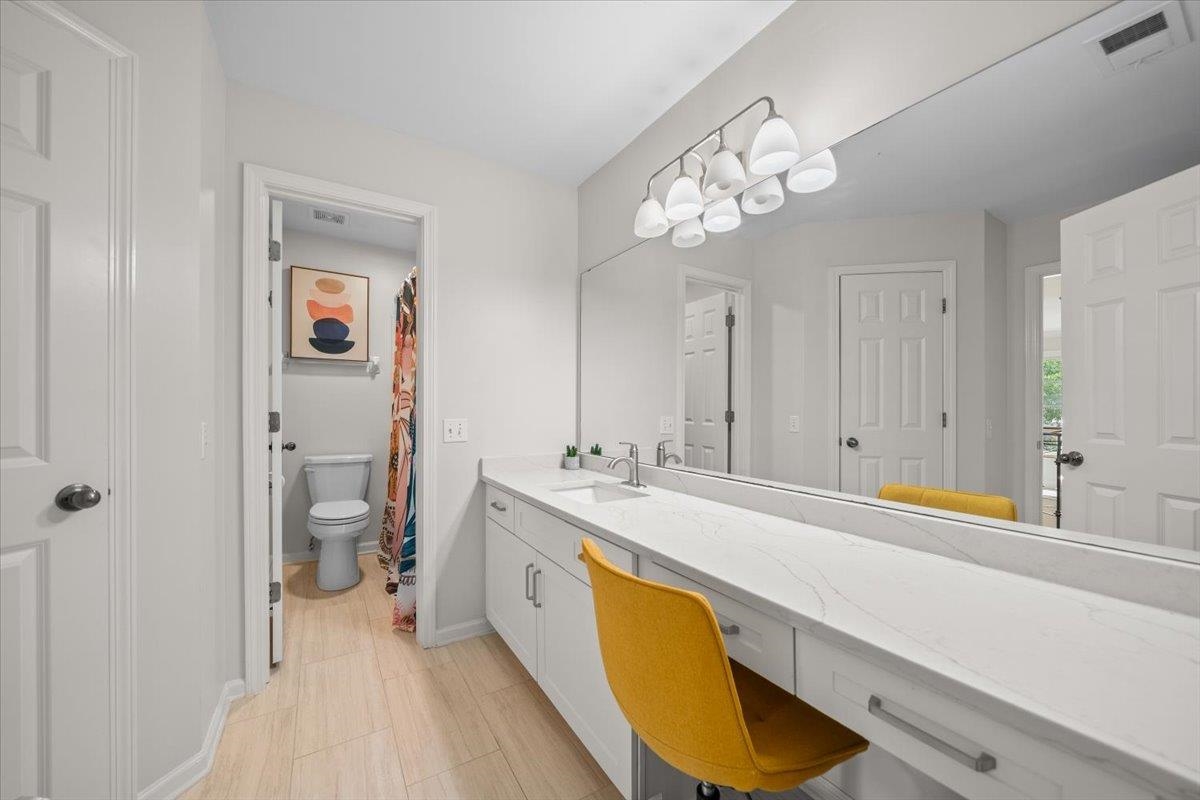 1876 Liles Lane Collierville, TN 38017 - Photo 22 of 36 Bathroom vanity featuring an extended countertop with a built-in dressing area, dual sinks, and white shaker-style cabinetry
