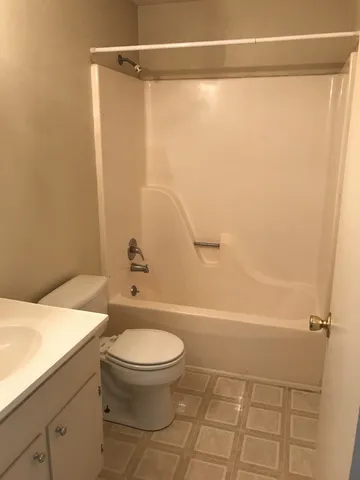 a white toilet sitting next to a bath tub