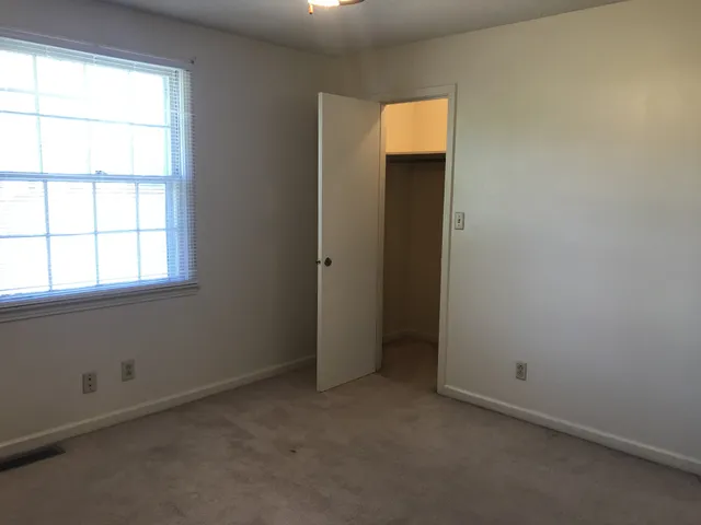 an empty room with windows and closet