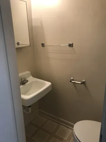 a bathroom with a sink mirror and toilet