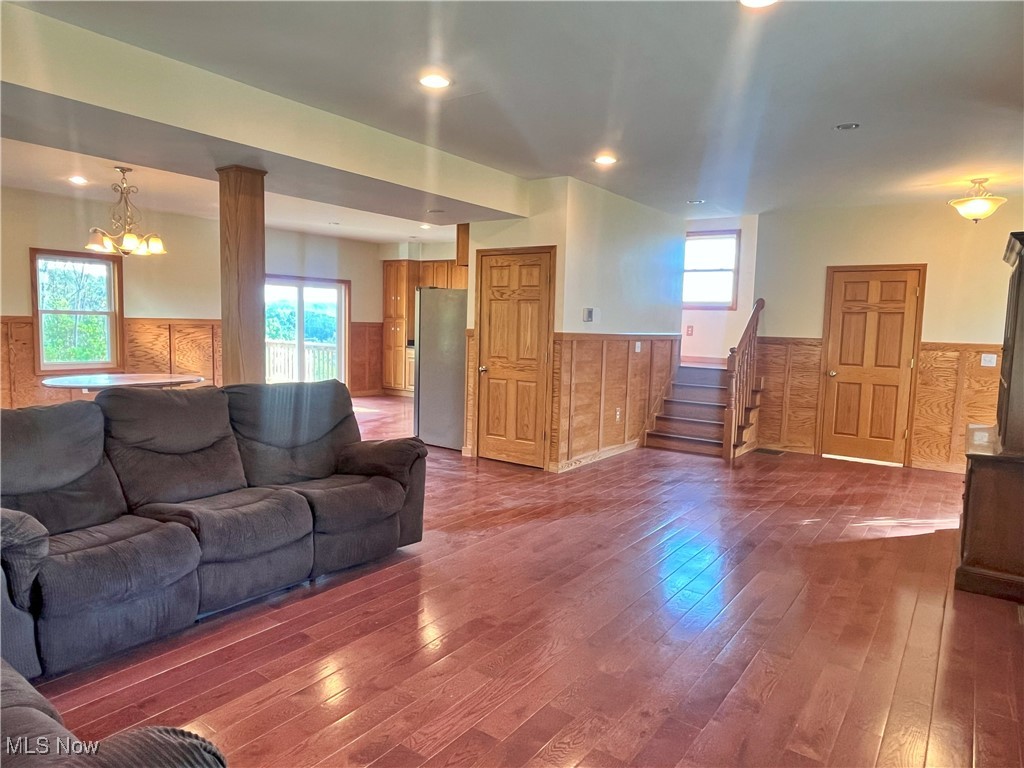 17583 Davis Ridge Road Caldwell, OH 43724 - Photo 19 of 42 Living area with wainscoting, dark wood-type flooring, a chandelier, stairs, and recessed lighting