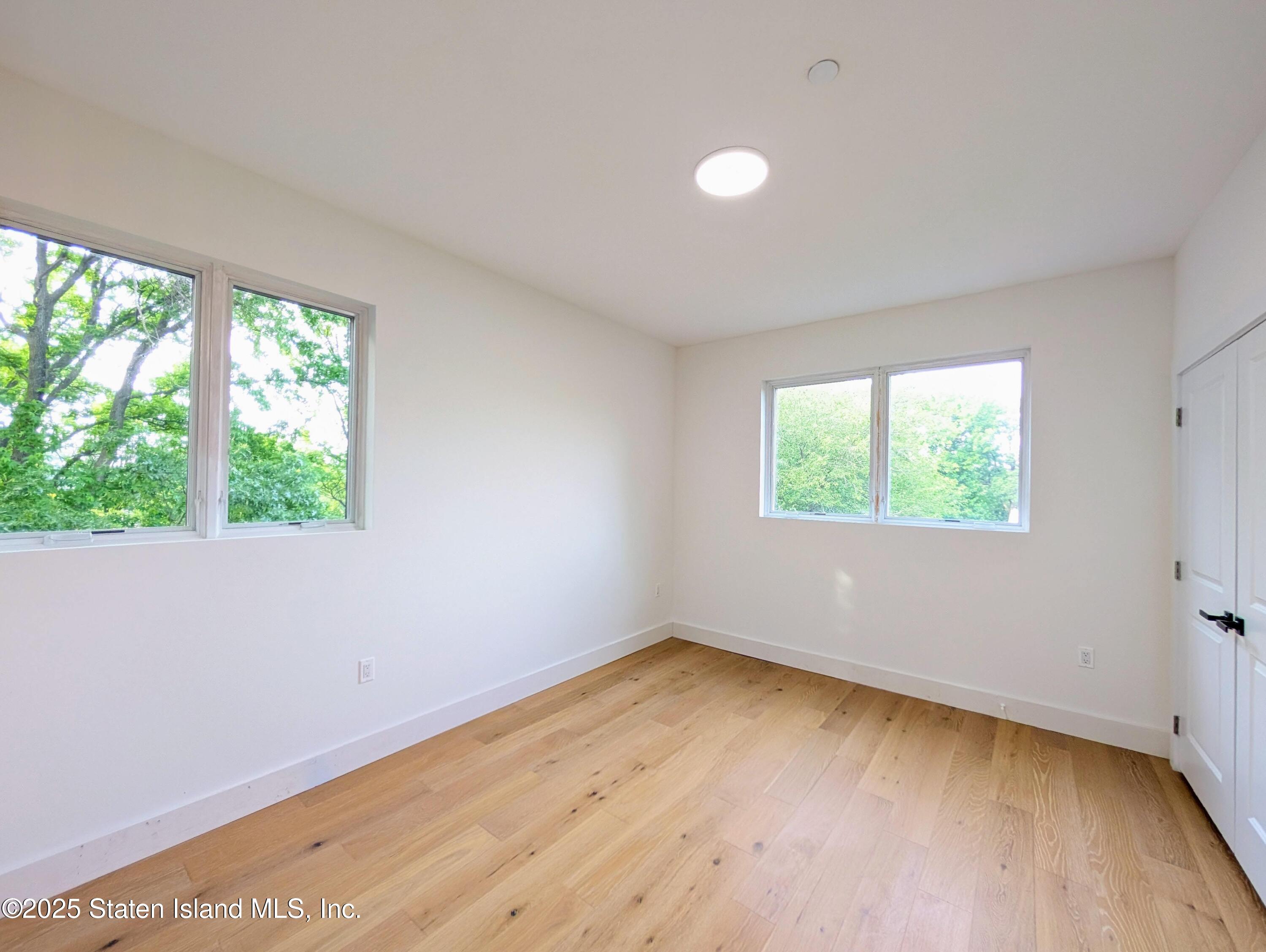 3865 Amboy Road, Unit 4B Staten Island, NY 10308 - Photo 13 of 20 an empty room with wooden floor and windows
