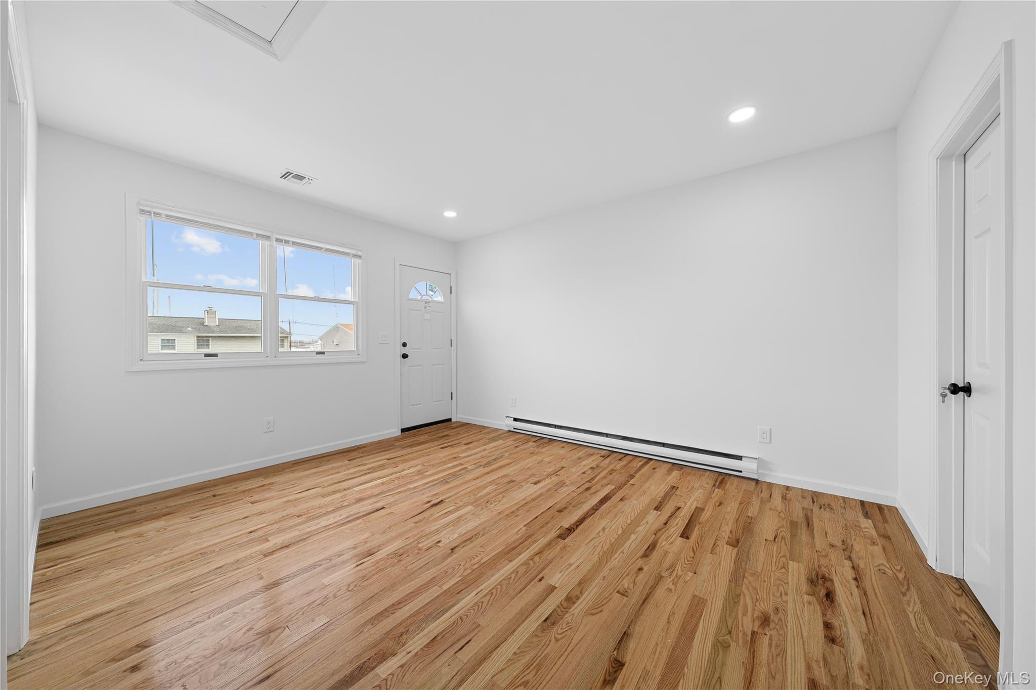 78 Layton Street Freeport, NY 11520 - Photo 12 of 22 wooden floor in an empty room with a window