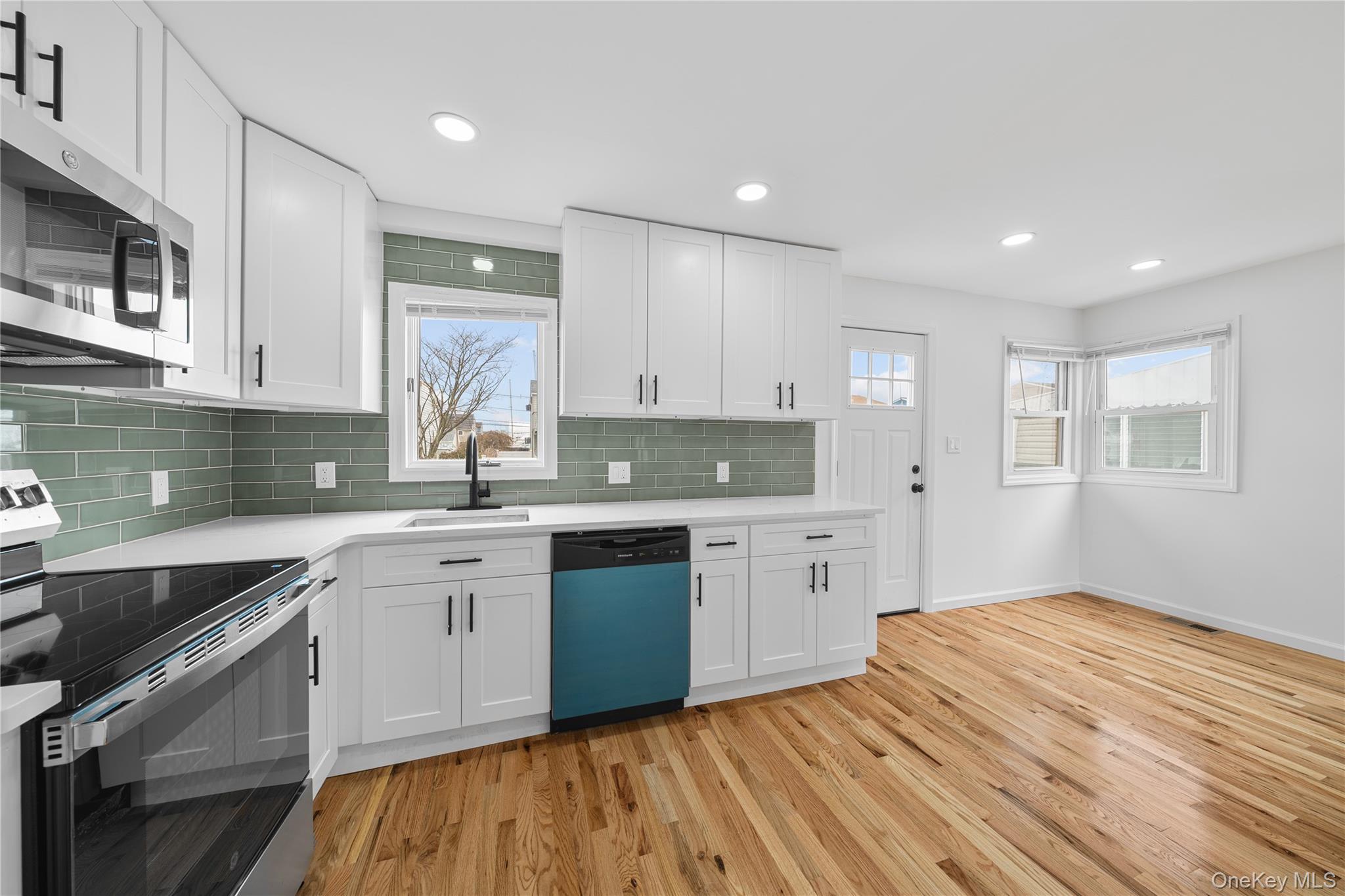 78 Layton Street Freeport, NY 11520 - Photo 18 of 22 a kitchen with granite countertop white cabinets stainless steel appliances a sink and a window