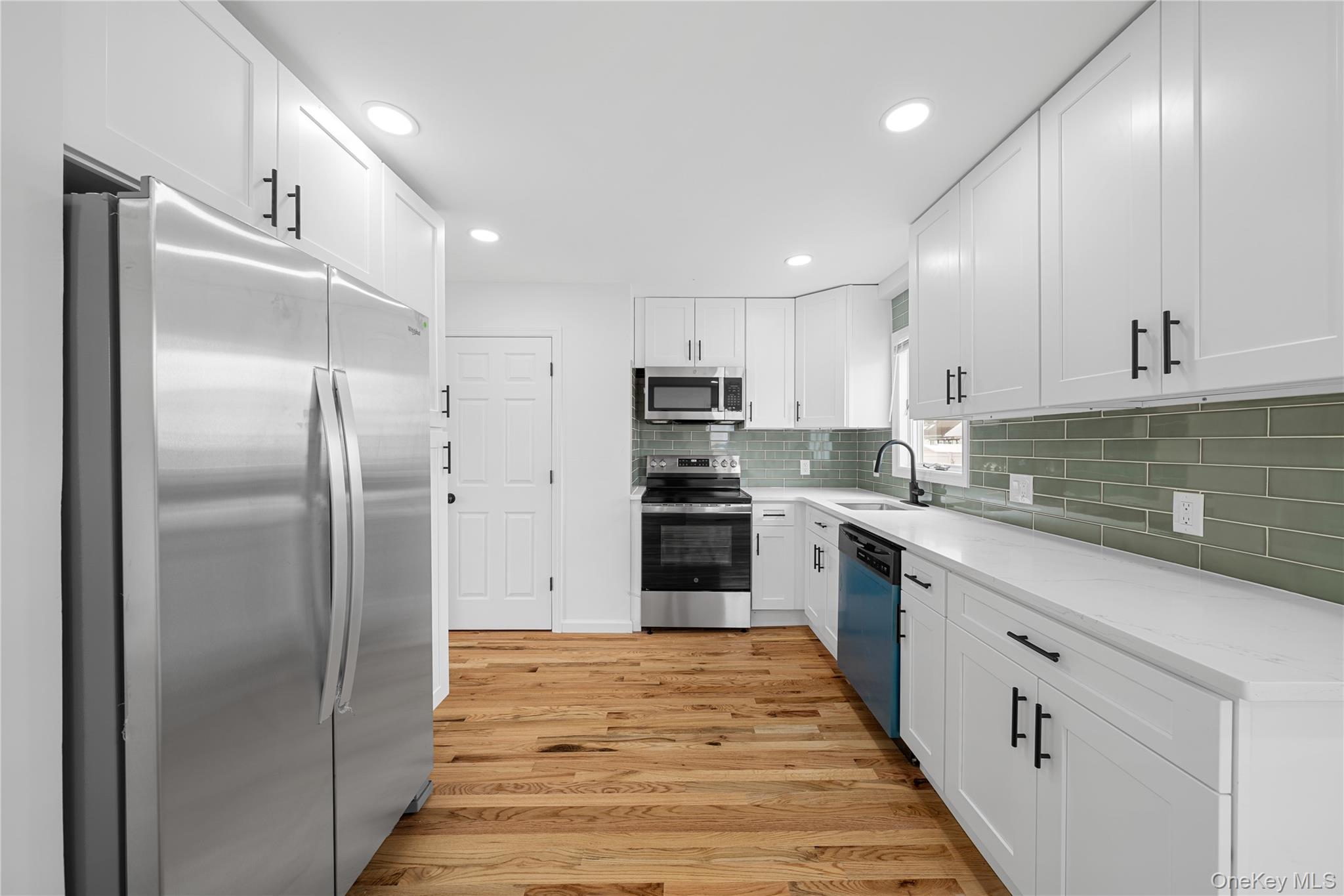 78 Layton Street Freeport, NY 11520 - Photo 19 of 22 a kitchen with stainless steel appliances granite countertop a refrigerator and a sink