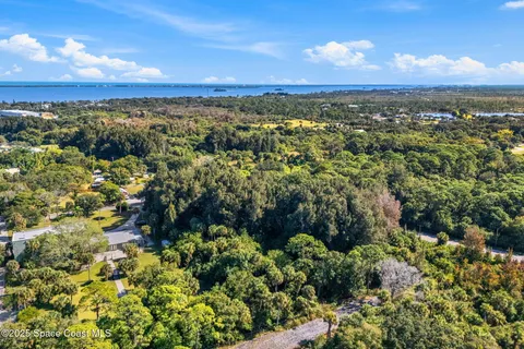 an aerial view of residential house with outdoor space and trees all around