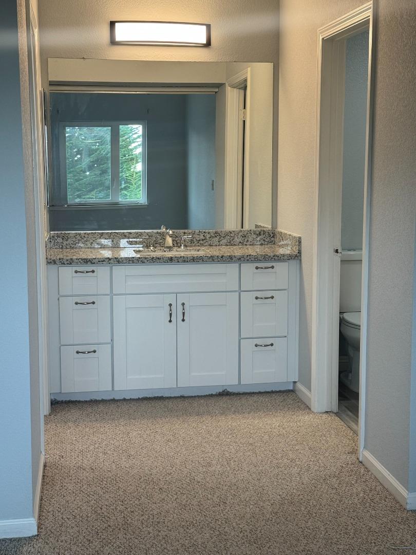 741 Pointe Pacific Drive, Unit 10 Daly City, CA 94014 - Photo 14 of 24 a bathroom with a granite countertop sink and a mirror