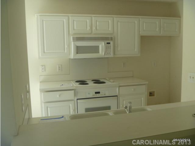 2214 Dawn Ridge, Unit 50 Monroe, NC 28110 - Photo 8 of 16 a kitchen with white cabinets and white appliances