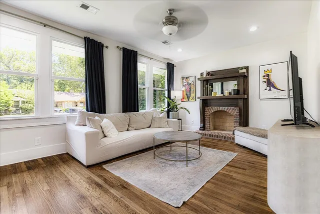 a living room with furniture large window and a fireplace