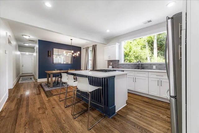 a kitchen that has a lot of cabinets in it and wooden floors