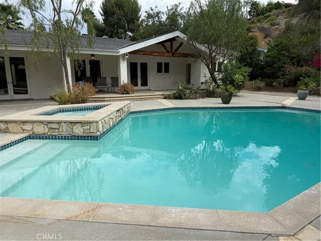 a view of a house with pool yard and sitting area