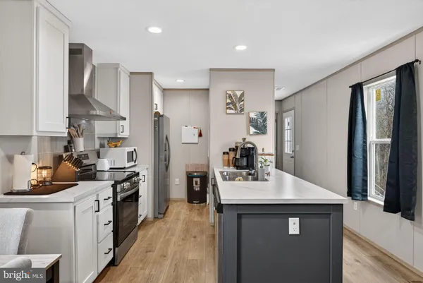 a kitchen with stainless steel appliances a sink stove refrigerator and cabinets