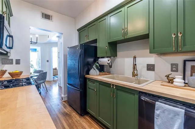 a kitchen with a sink a refrigerator and cabinets
